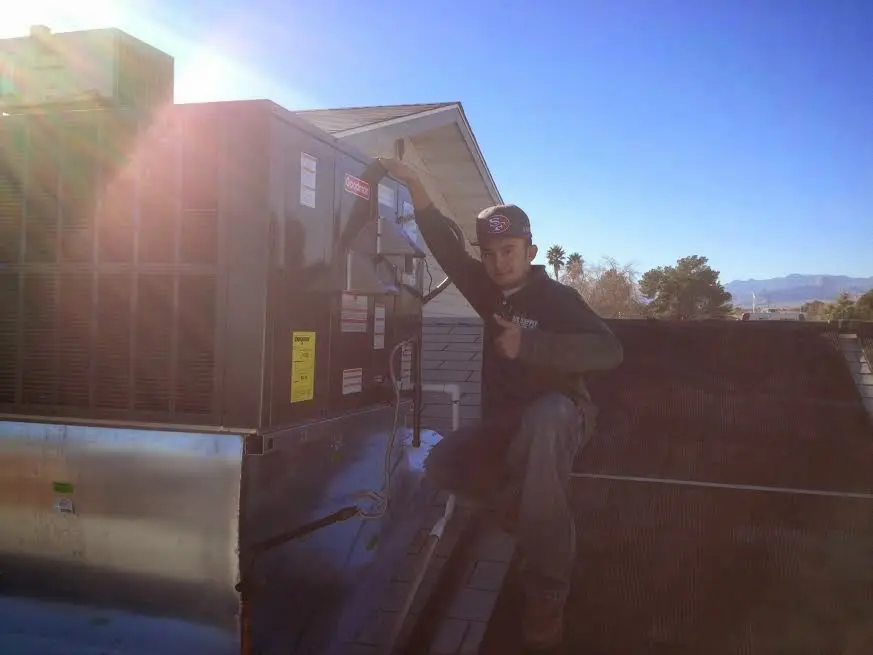 HVAC technician performing AC Tune-Up on a rooftop unit in Prospect Park